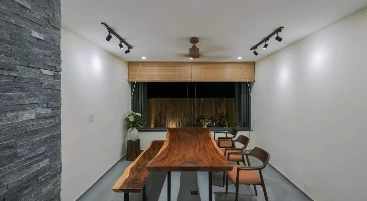 Bàn ăn gỗ me tây độc đáo trong phòng ăn của thiết kế nhà phố 4 tầng với điểm nhấn giếng trời thoáng đãng